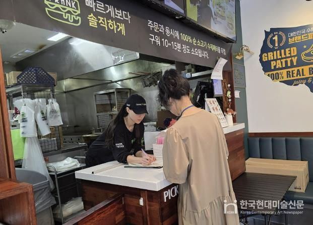 성남시 어린이 기호식품 전담관리원이 지난 9월 학교 주변 햄버거 판매점에서 영업자와 종업원의 건강진단 실시 여부를 점검하고 있다