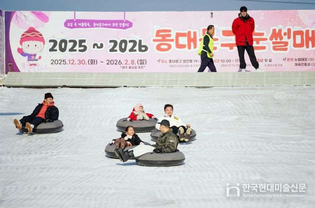 눈썰매를 타고 내려오는 이필형 구청장