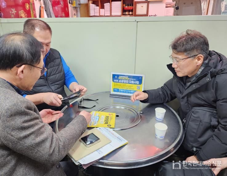소상공인 매니저가 사업장을 방문하여 지원사업을 설명하는 모습