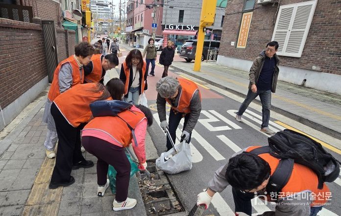 구로구소상공인연합회 회원들이 3월 31일 상권 일대에서 쓰레기 수거와 빗물받이 청소 등 환경정화 활동을 하고 있다.