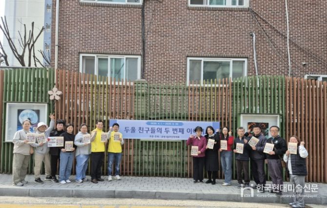 아산시 온양3동 주민자치회 위원 및 전시 참여 학부모들이 담장 갤러리에서 작품 교체 작업을 진행하고 있다.